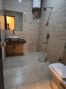 Hotel New City Lite في نيودلهي: حمام مع حوض ومرحاض ومرآة
