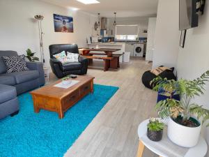 a living room with a couch and a table at Kerikeri Sunny Modern 2 Bedroom Apartment in Kerikeri