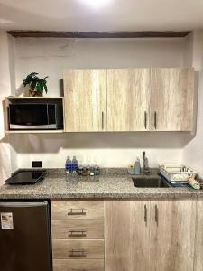 a kitchen with a sink and a microwave at Blacky Hostel and Apartments in Cusco