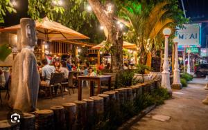 un ristorante all'aperto con persone sedute ai tavoli di notte di Casa/Piscina/Praia do Francês a Marechal Deodoro