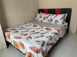 a bed with a colorful comforter and pillows at Homestay Samsul Sungkai in Sungkai