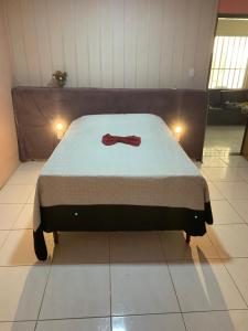 un letto con un farfallino in una stanza di Casa/Piscina/Praia do Francês a Marechal Deodoro