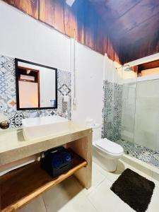La salle de bains est pourvue d'un lavabo et de toilettes. dans l'établissement Perro Loco Villas, à Paraíso