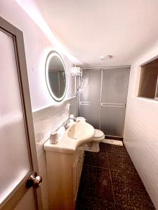 een badkamer met een wastafel, een toilet en een spiegel bij Blacky Hostel and Apartments in Cuzco