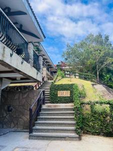 Una escalera que conduce a una casa con un cartel. en Sol Y Viento Mountain Hot Springs Resort en Calamba