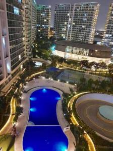 een uitzicht over een zwembad in een stad 's nachts bij Azure Urban Resort a12 Wavepool near mall airport in Manilla