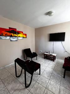 a living room with two chairs and a flat screen tv at Alquiler temporario zapala Amanecer in Zapala