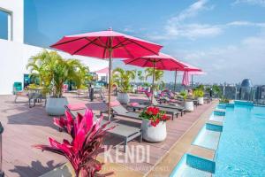 a swimming pool with chairs and umbrellas on a building at 2Bedroom Skynest Luxury Apartment Westlands City Views in Nairobi