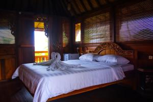 a bedroom with a bed with a swan on it at The Sangkih Villa Restaurant & Bar in Munduk