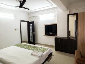 a bedroom with a bed and a flat screen tv at StayVilla Royal Executive Rooms in Rānchī