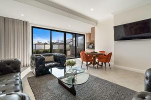 sala de estar con sofá y mesa de cristal en Sanlor Suite 2 - Luxury, Comfort & Style en Orange