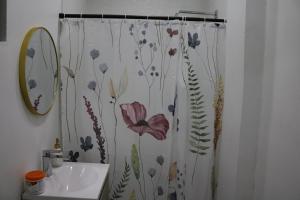 a bathroom with a shower curtain with flowers on it at Casa Francisca 