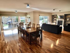 a living room with a table and chairs and a couch at Collins Retreat - 4 Bedroom home with Pool in Bright