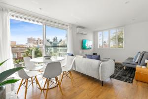 a living room with a couch and a table at Chic apartment footsteps from Manly Beach in Sydney