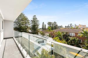 an open balcony with a view of trees and buildings at Chic apartment footsteps from Manly Beach in Sydney