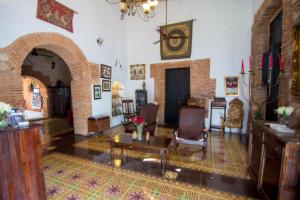 een woonkamer met een tafel en stoelen bij Boutique Hotel Colonial in Santo Domingo