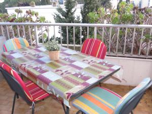 einen Tisch mit Stühlen und eine Decke auf einer Terrasse in der Unterkunft Appartement Sainte-Maxime, 2 pièces, 4 personnes - FR-1-780-63 in Sainte-Maxime