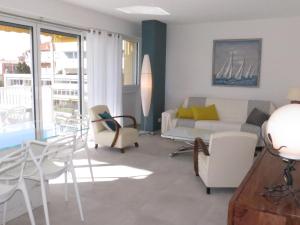 ein Wohnzimmer mit Couch und Stühlen in der Unterkunft Appartement 3 pièces avec terrasse, clim, wifi, garage en centre-ville à Sainte-Maxime - FR-1-780-57 in Sainte-Maxime