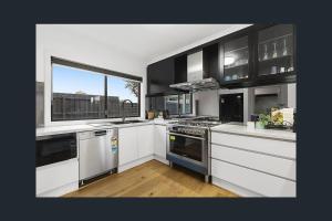a kitchen with black and white appliances and a window at 3 Bedroom Home in Cheltenham in Cheltenham