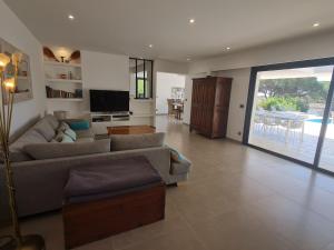 un salon avec un canapé et une télévision dans l'établissement Villa climatisée 6 pièces avec piscine privée, 5 chambres, Domaine de La Nartelle - FR-1-780-67, à Sainte-Maxime