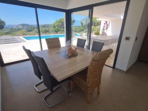 une table et des chaises de salle à manger avec vue sur une piscine dans l'établissement Villa climatisée 6 pièces avec piscine privée, 5 chambres, Domaine de La Nartelle - FR-1-780-67, à Sainte-Maxime