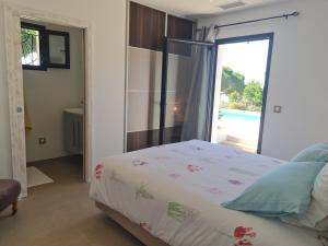 une chambre avec un lit et une porte donnant sur une piscine dans l'établissement Villa climatisée 6 pièces avec piscine privée, 5 chambres, Domaine de La Nartelle - FR-1-780-67, à Sainte-Maxime 24 autres photos