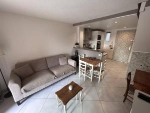 a living room with a couch and a table at Appartement 2 Chambres avec Climatisation et Jardin, à 400m de la Plage - Les Issambres - FR-1-768-72 in La Garonnette-Plage