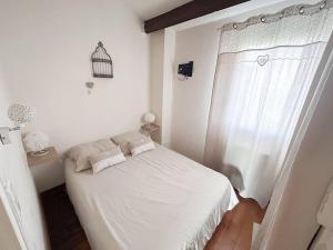 a small white bedroom with a bed and a bird cage at Appartement 2 Chambres avec Climatisation et Jardin, à 400m de la Plage - Les Issambres - FR-1-768-72 in La Garonnette-Plage