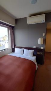 a bedroom with a large red bed with a window at ホテルアイシス掛川 in Kakegawa