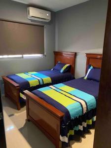 マサトランにあるHermosa Casa Vacacionalのベッド2台が隣同士に設置された部屋です。
