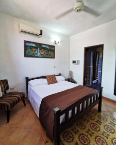 een slaapkamer met een groot bed en een stoel bij Boutique Hotel Colonial in Santo Domingo