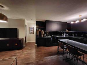 a large kitchen with black cabinets and a table at South Brisbane modern apartment in Brisbane