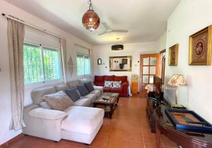 a living room with a couch and a table at 3 bedrooms chalet with shared pool terrace and wifi at Conil de la Frontera 7 km away from the beach in Hozanejos