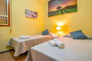 2 camas en una habitación con paredes amarillas en 2 bedrooms appartement at Galdar 150 m away from the beach with wifi, en Gáldar