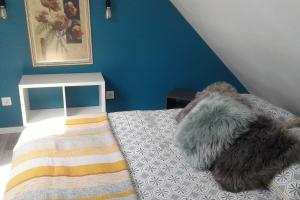 sypialnia z łóżkiem z niebieską ścianą w obiekcie Appartement cosy Wintzenheim + terrasse w mieście Wintzenheim