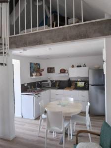 kuchnia ze stołem i krzesłami w pokoju w obiekcie Appartement cosy Wintzenheim + terrasse w mieście Wintzenheim