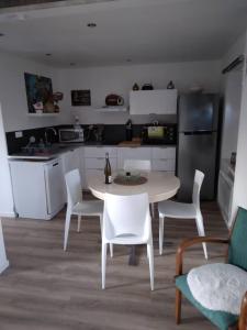 kuchnia ze stołem, krzesłami i stołem oraz kuchnia w obiekcie Appartement cosy Wintzenheim + terrasse w mieście Wintzenheim