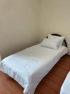 a white bed with white sheets and pillows on it at 1717 Bintulu Homestay 1 in Bintulu