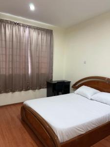 - une chambre avec un grand lit et une fenêtre dans l'établissement 1717 Bintulu Homestay 1, à Bintulu
