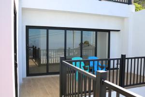 a balcony with glass doors and two blue chairs at Casa Francisca 