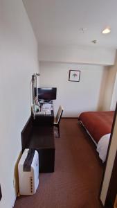 a hotel room with a bed and a desk with a computer at ホテルアイシス掛川 in Kakegawa