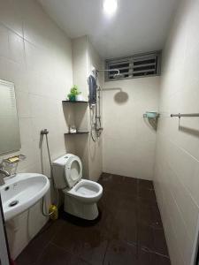 y baño con aseo blanco y lavamanos. en Mega Homestay, en Butterworth