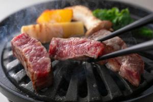 um monte de carne e vegetais numa grelha em KAMENOI HOTEL Fukui em Fukui