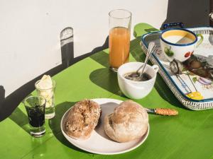 una mesa verde con un plato de pan y bebidas en One bedroom house with shared pool terrace and wifi at Figueira da Foz 4 km away from the beach, en Buarcos