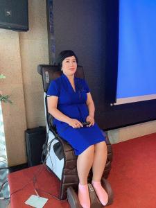 Una mujer con un vestido azul sentada en una silla en My home your home en Ho Chi Minh