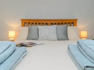a bedroom with a bed with pillows and two lamps at 1 Bed in Whatton 77805 in Bingham
