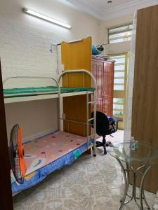 Habitación con 2 literas y mesa de cristal. en My home your home en Ho Chi Minh