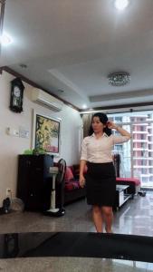 una mujer parada en una sala de estar cepillándose el pelo en My home your home en Ho Chi Minh