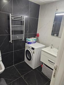 ein Badezimmer mit einer Waschmaschine und einem Waschbecken in der Unterkunft Comfortable luxury apartment in Istanbul