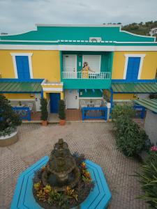 a colorful house with a fountain in front of it at Hotel Boutique Calizo vip in Fajardo